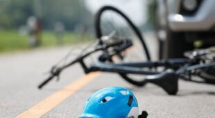 Sturzunfall Radfahrer infolge Bremsvorgangs des vor ihm fahrenden Pkws auf regennasser Fahrbahn