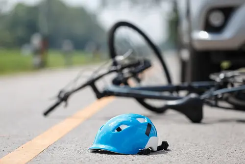 Sturzunfall Radfahrer infolge Bremsvorgangs des vor ihm fahrenden Pkws auf regennasser Fahrbahn