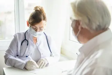 Corona-Pandemie – Tragen Mund-Nase-Bedeckung in Arztpraxis
