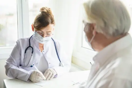 Corona-Pandemie - Tragen Mund-Nase-Bedeckung in Arztpraxis