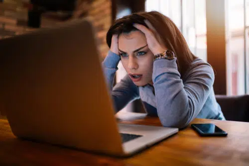 Frustrated,Worried,Young,Woman,Looks,At,Laptop,Upset,By,Bad