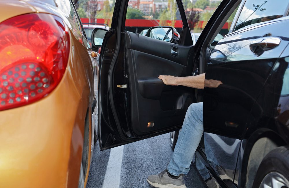 Verkehrsunfall in Parktasche beim Ausfahren und geöffneter Tür des Nachbarfahrzeugs