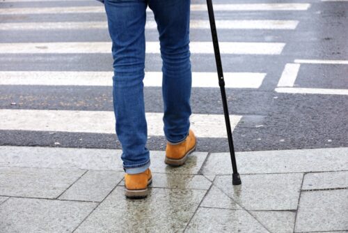 fußgänger mit gehilfe überquert straße