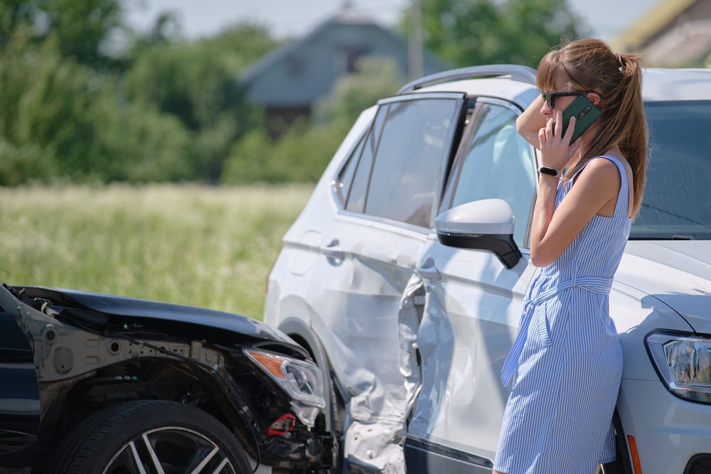 Stressed,Driver,Talking,On,Sellphone,On,Roadside,Near,Her,Smashed Kreuzungskollision - irreführend verhaltender Vorfahrtberechtigter mit Wartepflichtigen