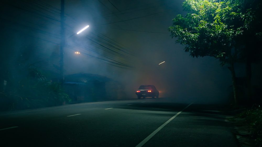 Classic,Car,Drive,Into,Abandoned,Road,With,Large,Group,Of Verkehrsunfall bei Dunkelheit: Wer haftet bei Kollision mit geparktem Fahrzeug?