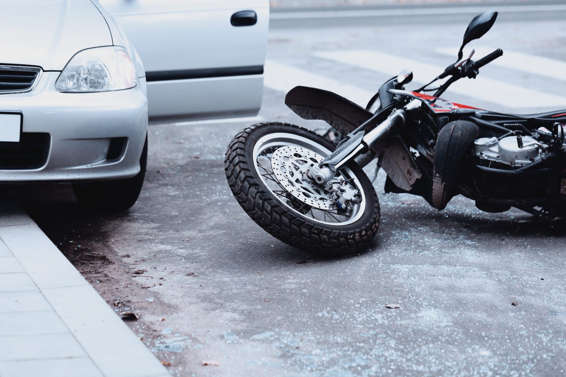 Motorcycle,Lying,On,The,Road,And,Car,Standing,With,Open Offene Fahrertür: Unfallgefahr im fließenden Verkehr