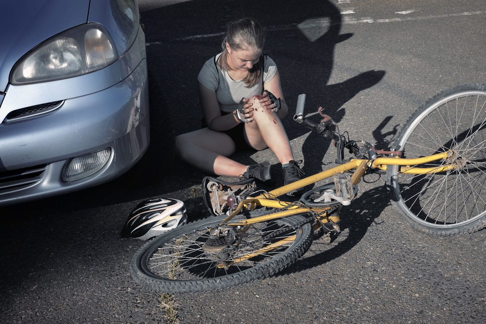 Teenage,Girl,Cyclist,Is,Injured,And,Sitting,On,Road,After Verkehrsunfallverursachung eines 14-Jährigen aufgrund einer Vorfahrtsverletzung
