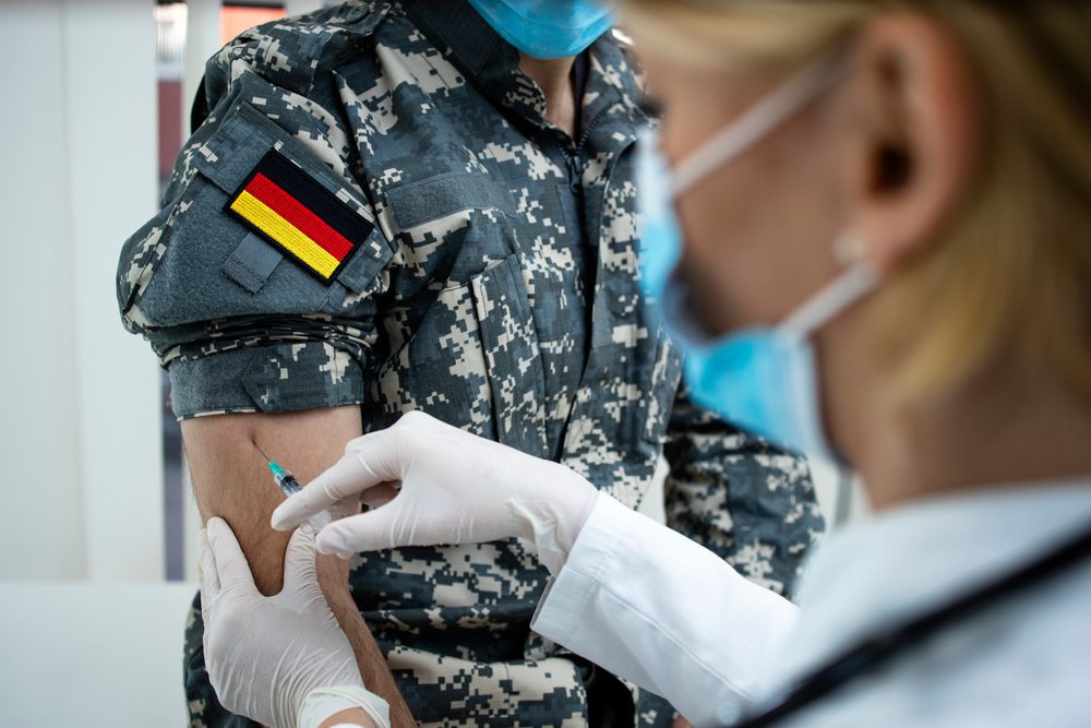 Soldat erhält Impfung, Deutschlandfahne am Ärmel.