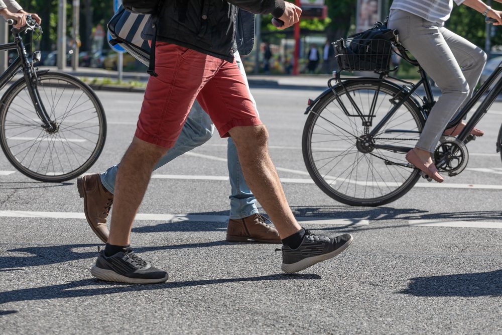 Pedestrians,And,Cyclists,Cross,A,Street Fußgänger und Radfahrer überqueren Straße.