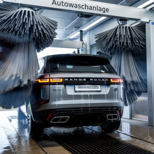 Range Rover während der Reinigung in automatischer Waschanlage mit rotierenden Bürsten