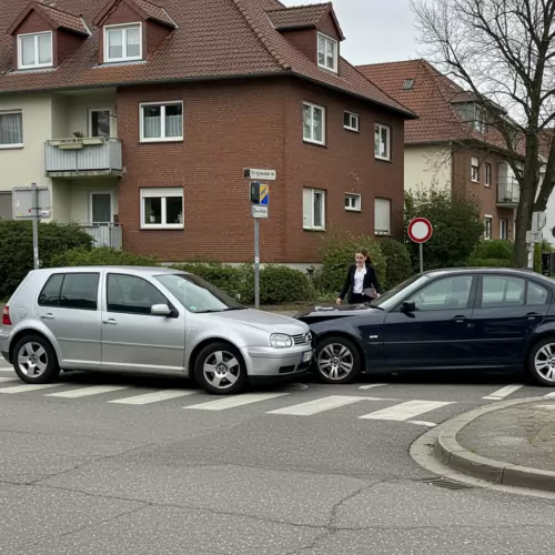 Zwei kollidierende Autos auf einer deutschen Straße, Fahrer steigen aus, sichtbare Schäden an Fahrzeugen.
